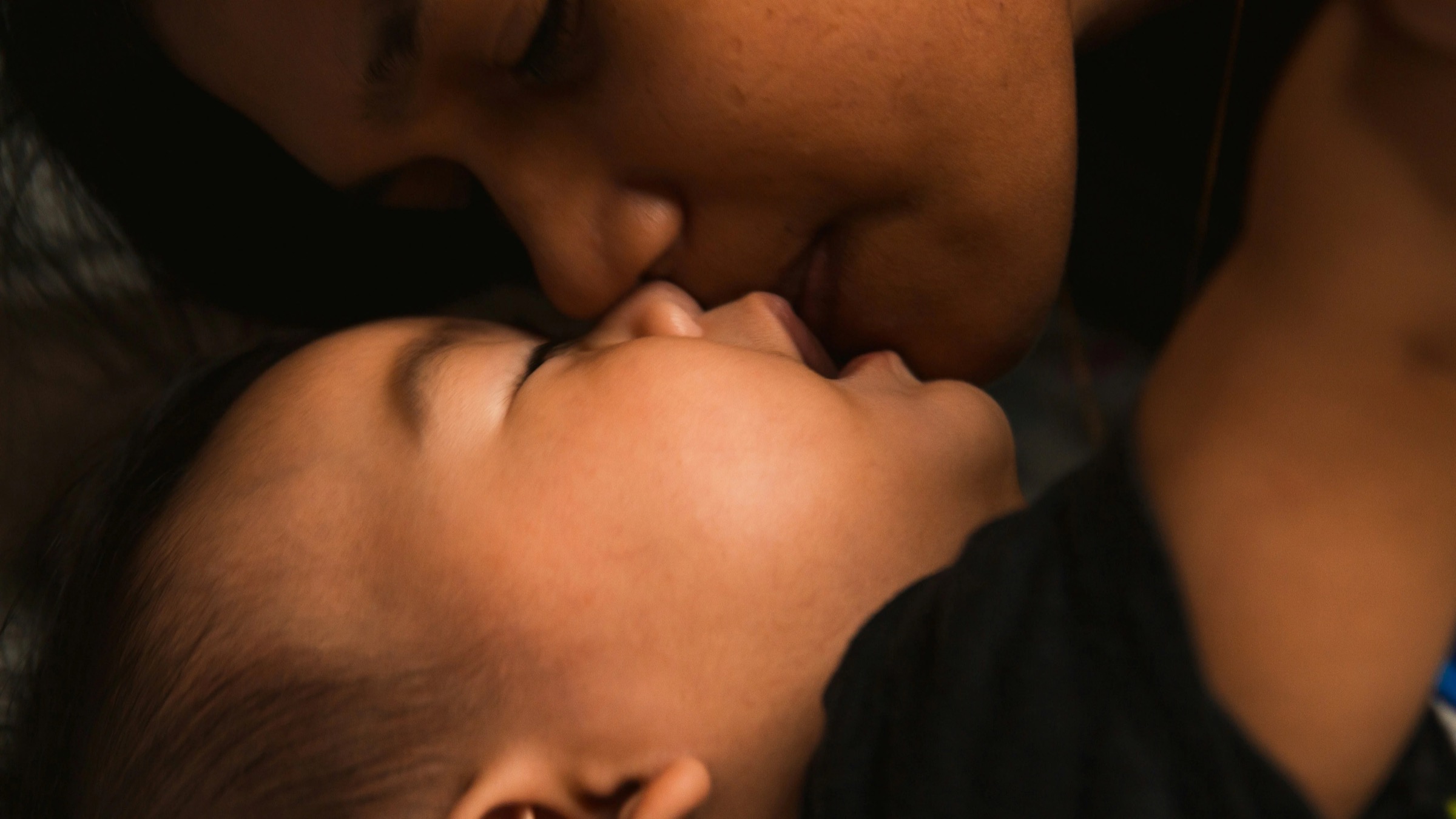 A mother holding her baby close, forehead to forehead