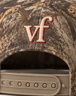 Close-up of the cream vf monogram outlined in red above the adjustable strap